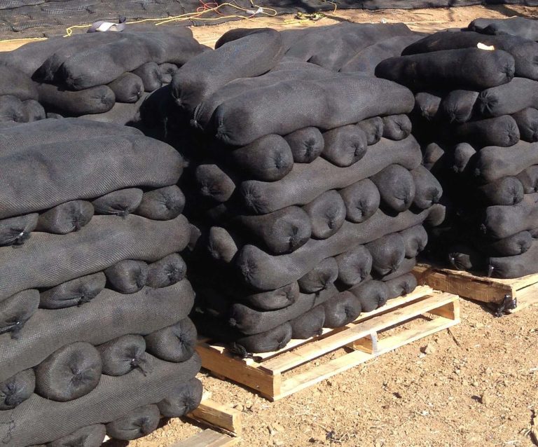 Pallets of filled GroSoxx units on a job site