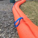 StormCatcher weighted sediment filter tube installed on a gravel shoulder