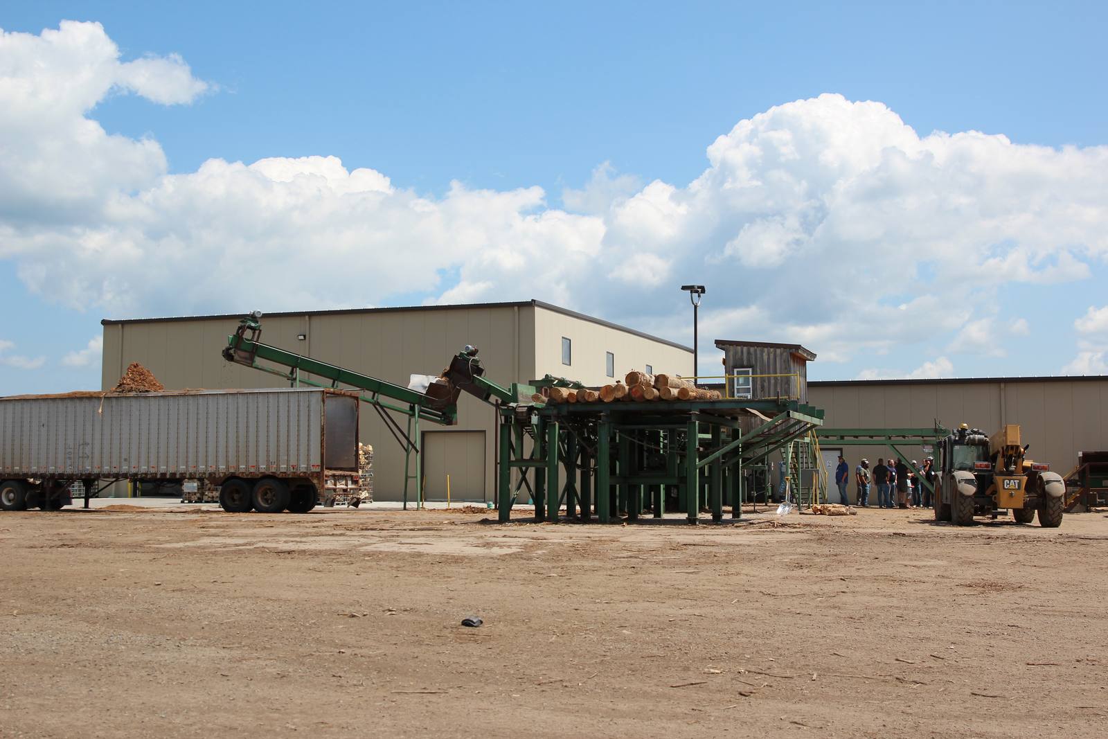 Conveyor, trailer and loader working in the yard at an MKB plant
